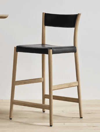A contemporary bar stool with a wooden frame and a black upholstered seat and backrest. The stool features a curved backrest that extends from the frame. The legs are made of light-colored wood and are connected by horizontal support rails, providing stability. The seat and backrest appear to be upholstered in a dark, possibly leather, material. — 3D model