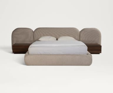 A contemporary upholstered bed featuring a low-profile frame and an extended, multi-panel headboard with rounded edges. A dark wood nightstand is positioned next to the bed, appearing to be integrated into the overall design. The bed and headboard are covered in a light beige, textured fabric. — 3D model