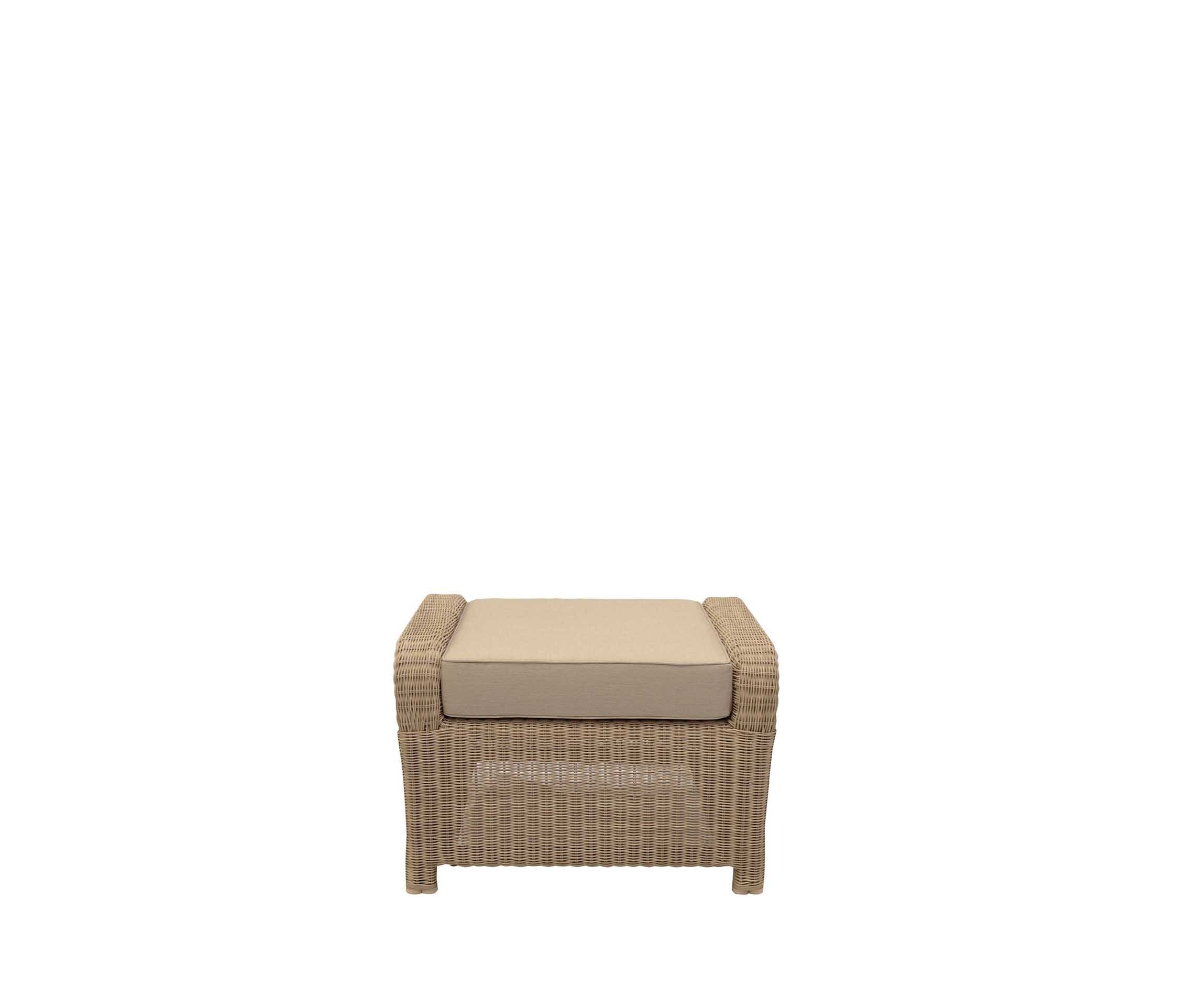 A rectangular outdoor ottoman featuring a woven wicker frame in a light brown or beige tone, topped with a thick, removable beige fabric cushion. The wicker extends down to form integrated low feet, and the construction suggests durability for exterior use. — 3D model