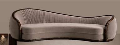 A gracefully curved sofa upholstered in a light beige velvet, featuring a prominent dark wood trim with decorative nailhead detailing along its serpentine backrest and base. The interior backrest exhibits vertical channel tufting. — 3D model