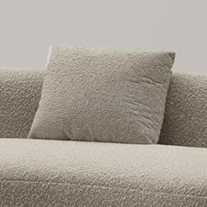 A large, modular, curved sofa with a textured, boucle-like upholstery. The sofa features rounded edges and appears to be composed of at least two connected sections, forming a sweeping arc. It includes two square throw pillows that match the sofa's upholstery. The design is contemporary with a soft, inviting aesthetic. — 3D model