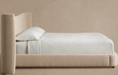 A contemporary upholstered platform bed featuring a distinctive winged headboard. The entire frame, including the headboard and bed base, is covered in a light beige, textured fabric. The headboard has a central seam and gracefully curved, outward-flaring wings on either side, providing a soft, enveloping aesthetic. The bed sits low to the ground on small, discreet feet. — 3D model