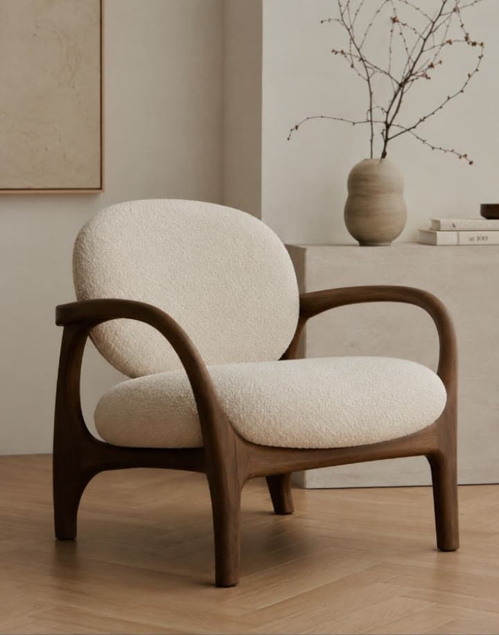 A contemporary lounge chair featuring a sculptural dark wood frame and plush, rounded bouclé upholstery. The chair has a minimalist yet organic design, with seamlessly integrated armrests that flow into the legs. The backrest and seat cushions are generously padded, providing a comfortable seating experience. — 3D model