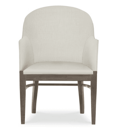 A cream-colored armchair with a high, curved back and upholstered arms. The seat is also upholstered in the same fabric. The frame and legs are made of wood with a weathered, gray-brown finish. The legs have a slightly tapered profile. — 3D model