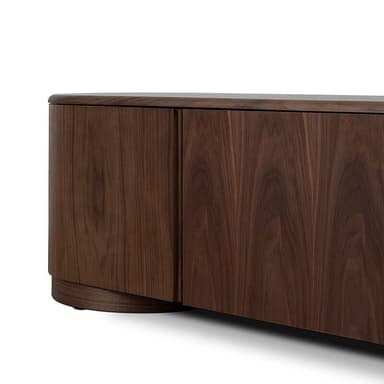A long, low wooden cabinet featuring four door panels and distinctively rounded ends, crafted from a dark, richly grained wood. The piece sits on a recessed base, maintaining a clean, grounded silhouette. — 3D model