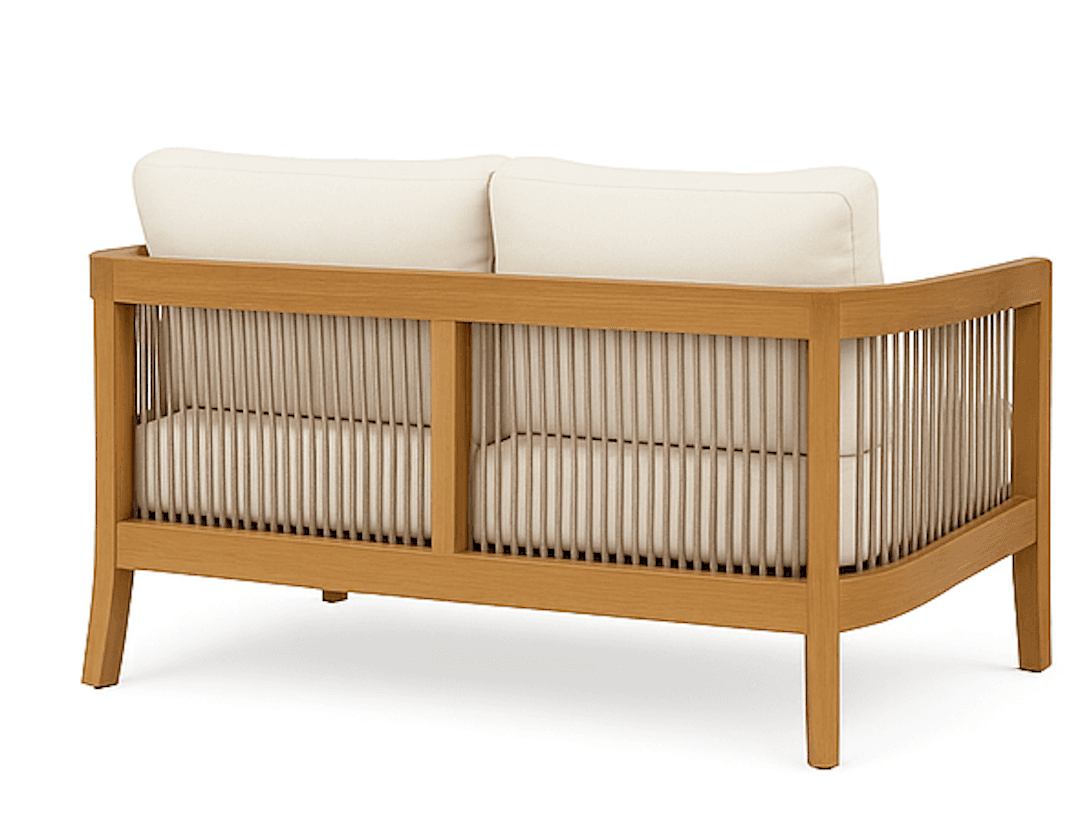 A two-seater sofa with a light wood frame and a slatted backrest. The sofa features two plush, rectangular cushions for the back and a seat cushion. The frame is constructed from light-colored wood and has a clean, modern design with slightly tapered legs. The backrest is composed of numerous vertical wooden slats, creating a visually airy effect. The cushions are upholstered in a neutral-toned fabric. — 3D model