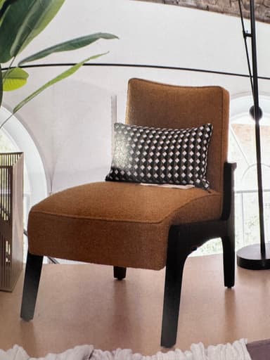 An armless lounge chair featuring camel-colored textured upholstery and a contrasting dark, minimalist frame, complete with a geometric patterned accent pillow. — 3D model