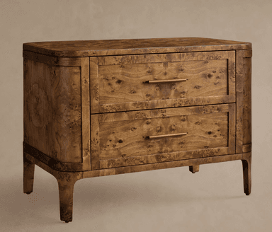 A compact two-drawer nightstand or side cabinet crafted from burl wood veneer, featuring a rich, intricate grain pattern. The piece has soft, rounded corners on its top and sides, and the base flows seamlessly into four short, tapered legs. It is equipped with two full-width drawers, each fitted with a slender, rectangular brass or bronze bar pull handle. — 3D model
