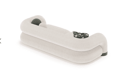 A contemporary sofa upholstered in off-white boucle fabric, featuring distinct rounded and organic forms for its back, arms, and seat cushions, resting on a low, dark-toned base. It includes an abstract patterned accent pillow and a small spherical dark green pillow. — 3D model