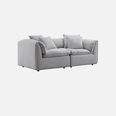 A contemporary, light gray two-seater sofa featuring a plush and inviting design. It consists of two main upholstered sections, providing generous seating. The sofa has thick, soft cushions for both the seat and back, along with several matching throw pillows, all upholstered in a uniform light gray fabric with subtle piping detail. The armrests are wide and softly padded, integrated into the overall plush aesthetic. The piece appears designed for maximum comfort and relaxation, with a low profile and a substantial, inviting presence. — 3D model
