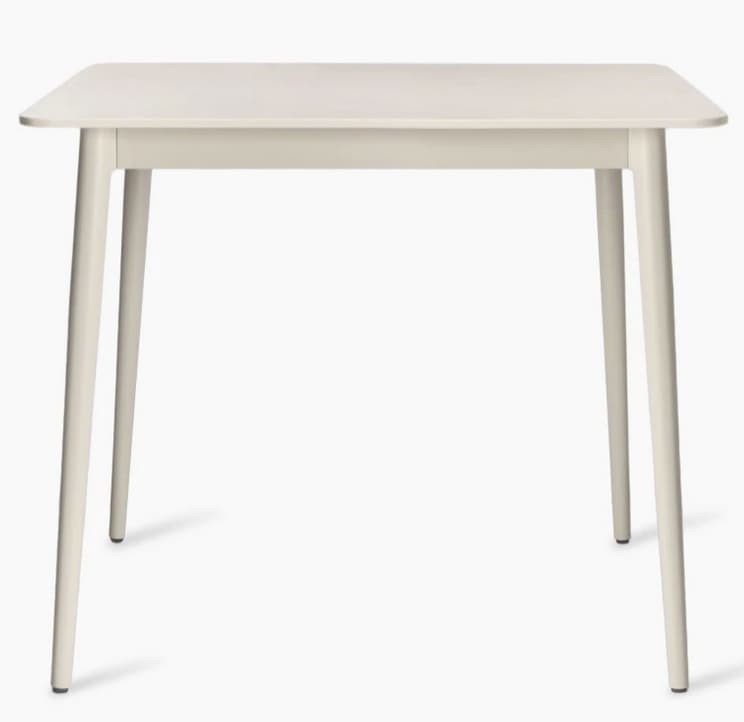 A square-shaped dining table with rounded corners and four tapered legs. The table has a smooth, matte finish and appears to be constructed from a solid material. — 3D model