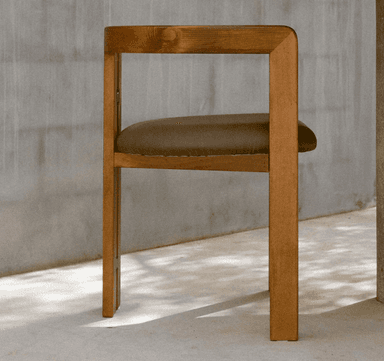 A wooden chair with a cushioned seat and a distinct 'butterfly' joint connecting the vertical support beams. The chair has a minimalist design with clean lines, featuring four legs, a seat, and a backrest composed of two vertical posts connected by a horizontal element near the top. The wood appears to be a medium-toned hardwood. — 3D model