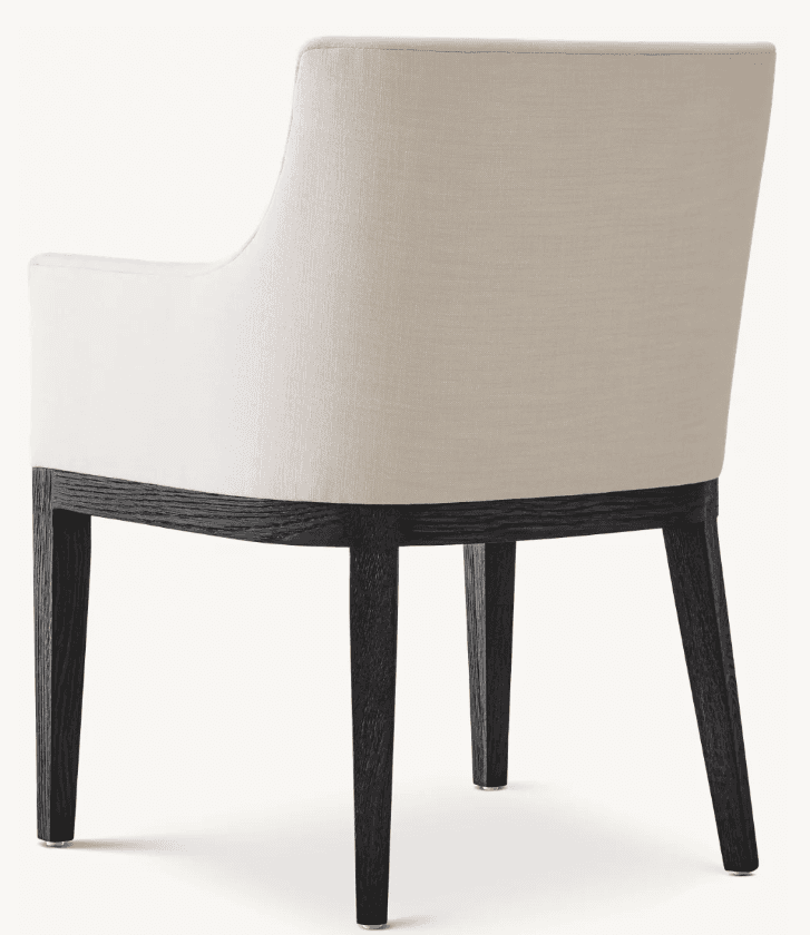An upholstered dining armchair with a subtly curved backrest and armrests, supported by four tapered dark wood legs. The upholstery is a light, neutral fabric, contrasting with the dark finish of the wood frame, which displays a prominent grain. — 3D model