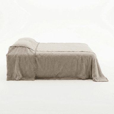 A bed with a taupe-colored duvet or comforter that appears to be made of linen. The bedding has a raw, frayed edge detail along the seams and the overhang. — 3D model