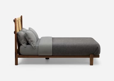 A loveseat seen from the back, featuring a dark walnut wood frame and a light-colored woven natural fiber backrest. The frame is composed of horizontal and vertical wooden members, within which two distinct woven panels are secured. A dark gray cushion is partially visible through the woven material. — 3D model