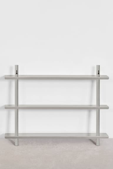 A modern, minimalist wall-mounted shelf unit featuring three rectangular shelves made of brushed silver-gray metal. The shelves are supported by two vertical cylindrical rods that extend from the floor to above the top shelf, where they feature keyhole-style wall mounting brackets. The design is sleek and industrial. — 3D model