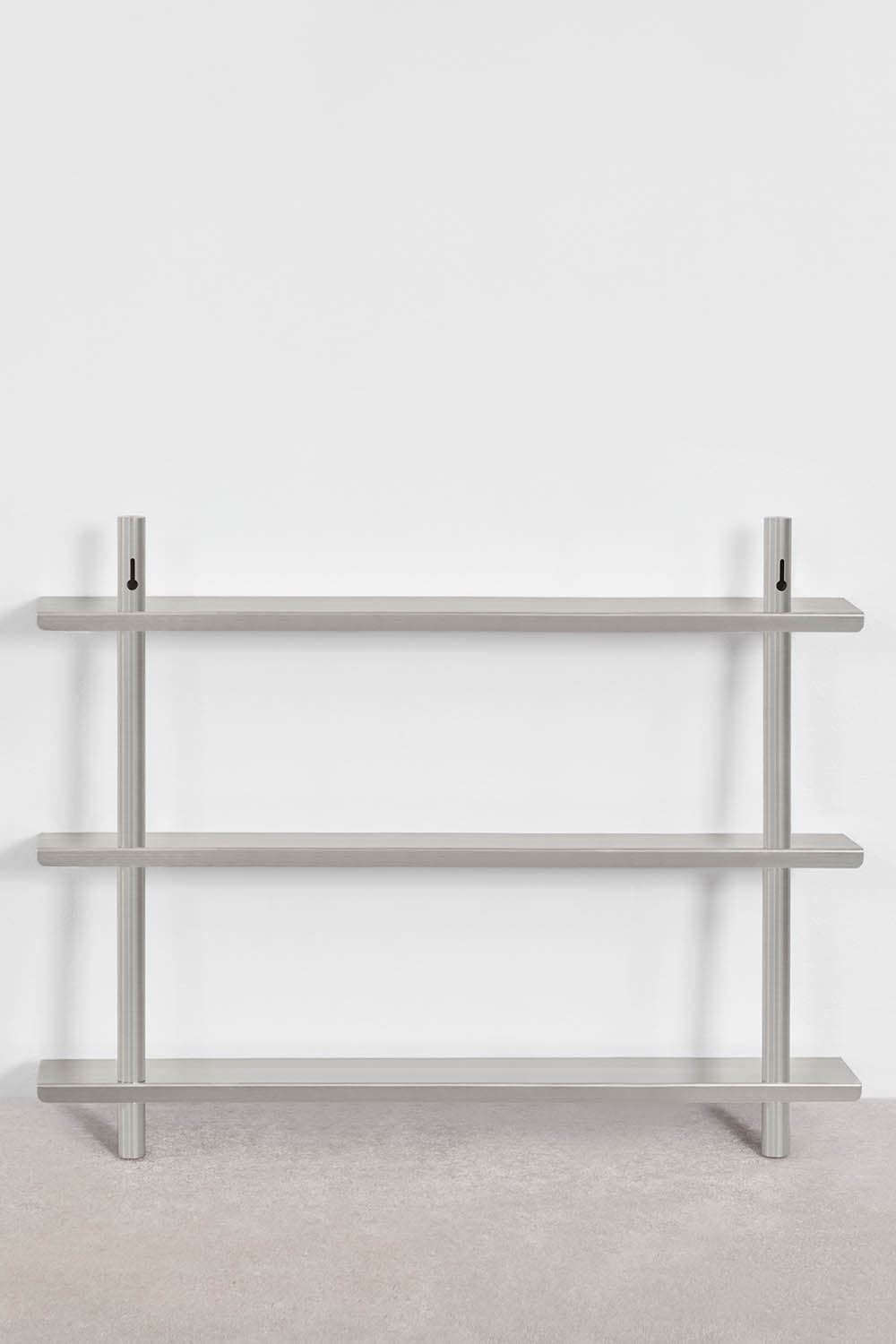 A modern, minimalist wall-mounted shelf unit featuring three rectangular shelves made of brushed silver-gray metal. The shelves are supported by two vertical cylindrical rods that extend from the floor to above the top shelf, where they feature keyhole-style wall mounting brackets. The design is sleek and industrial. — 3D model