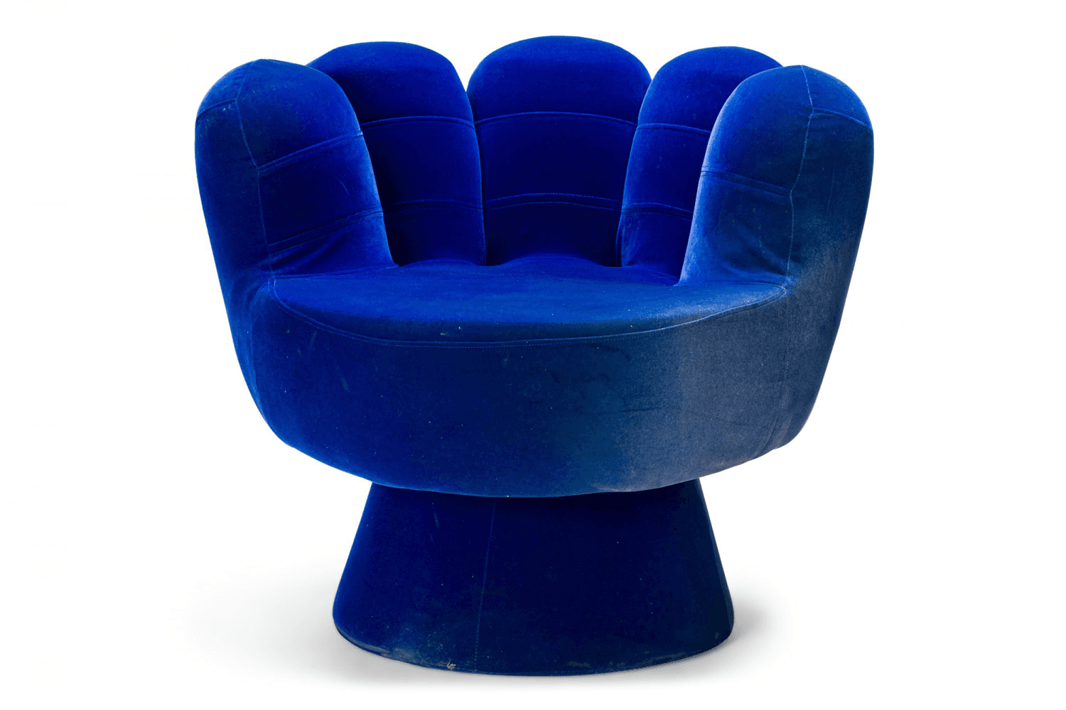 A vibrant blue velvet accent chair designed to resemble a hand. The chair features a padded seat and backrest, with five distinct 'finger' sections forming the back and armrests. It is supported by a dark, cylindrical base. The upholstery has a plush texture, characteristic of velvet, and the overall form is whimsical and stylized. — 3D model