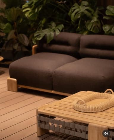 A modern two-seater sofa featuring a robust wooden frame and dark brown textured upholstery. The design incorporates distinctive woven detailing on the armrest sides and prominent block-style wooden legs. — 3D model