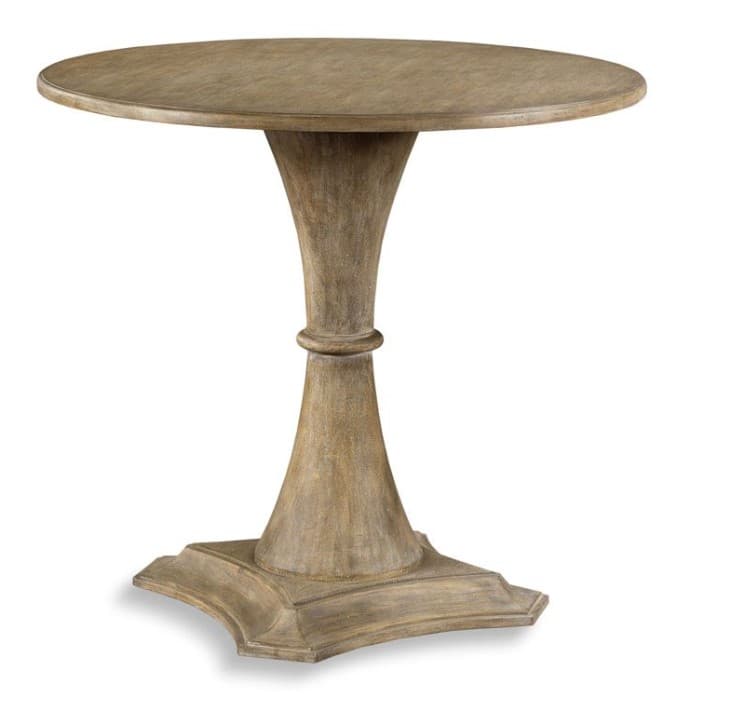 A round accent table with a single pedestal base. The pedestal has a flared, trumpet-like shape with a decorative ring in the middle and flares out to a square base with curved edges. The table appears to be constructed from wood with a distressed, weathered finish. — 3D model