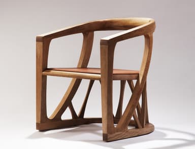 A contemporary armchair crafted from light-colored solid wood, featuring a gracefully curved backrest and integrated armrests. The chair incorporates a geometric, sculptural base with multiple intersecting wooden struts providing support. A contrasting reddish-brown leather cushion forms the seat, complementing the natural wood tone. — 3D model