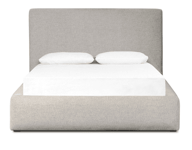A modern platform bed, fully upholstered in a light grey or oatmeal-colored textured fabric. It features a streamlined, low-profile design with a built-in rectangular headboard and rounded edges on the frame. The bed frame encloses a mattress, which is visible with white sheets and two white pillows. — 3D model