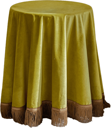 A round table completely covered by a floor-length, olive green velvet tablecloth. The tablecloth features a decorative fringe trim in a contrasting brown color along its bottom edge. The velvet fabric displays a soft sheen and drapes in gentle folds around the table, obscuring the base. The fringe is segmented by a patterned band just above the tassels. — 3D model