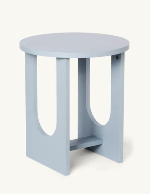 A round-topped end table with a light blue finish. It features four legs with an open, U-shaped cutout design, connected by a lower stretcher shelf. The design is minimalist and modern. — 3D model