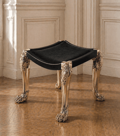A low, square-shaped ottoman featuring a black velvet upholstered top set within a black lacquered frame. It stands on four highly ornate, gilded metallic legs, sculpted with lion's heads at the top and lion's paws as feet. — 3D model