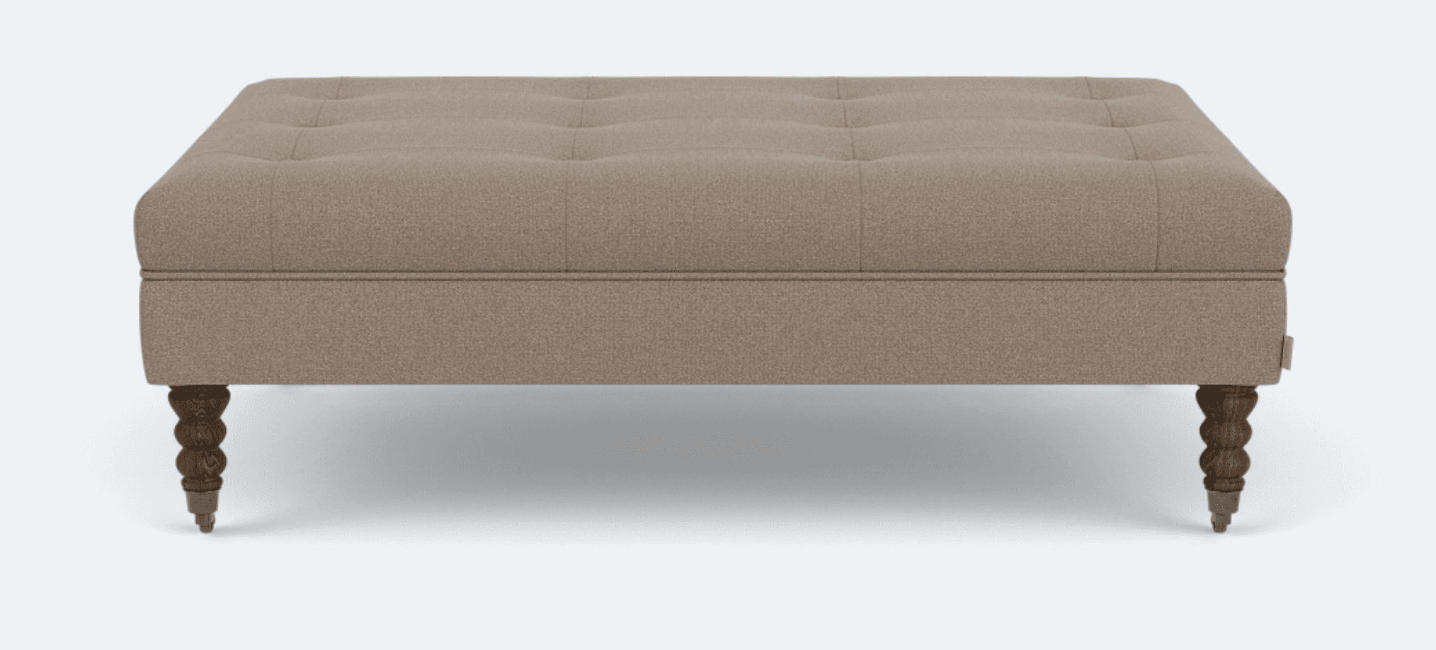 A rectangular ottoman with tufted upholstery and four carved wooden legs. The upholstery appears to be a textured fabric, and the legs have a turned, decorative design. — 3D model