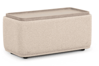 A rectangular upholstered ottoman featuring gently rounded corners and a soft, textured fabric top and frame. The sides are adorned with recessed panels showcasing a light-colored wood grain finish, creating a contrast in texture and material. — 3D model