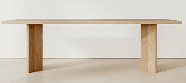 A rectangular dining table crafted from solid, light-toned oak wood, featuring a thick slab top supported by two robust, vertical panel legs. The design is minimalist and contemporary, emphasizing the natural grain of the wood. — 3D model
