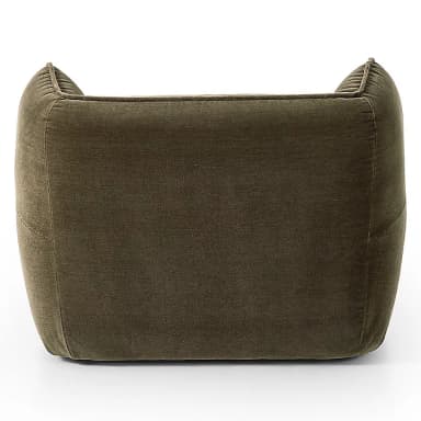 A plush, olive green velvet upholstered lounge chair featuring rounded, integrated armrests and a high back with soft, wing-like side panels. The chair's design emphasizes comfort with its deep seating and soft, inviting contours, highlighted by subtle piping along the seams. — 3D model