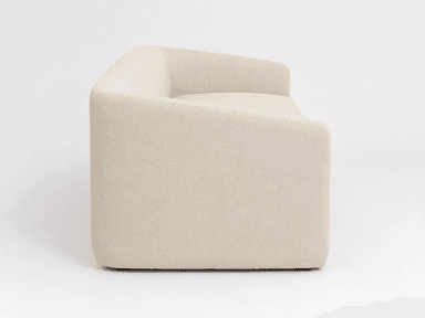 A contemporary upholstered sofa featuring a minimalist design with softly rounded armrests and a unified, clean aesthetic. The sofa is covered in a light beige, textured fabric and has a single, long seat cushion. The base is also upholstered, creating a continuous profile without visible legs, and exhibits a subtle inward curve at the bottom front. — 3D model