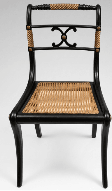 A refined Regency-style side chair featuring a black lacquered wooden frame, a woven cane seat, and decorative rope detailing on the back supports. The chair has a curved backrest with a carved central motif and subtly splayed saber legs. — 3D model