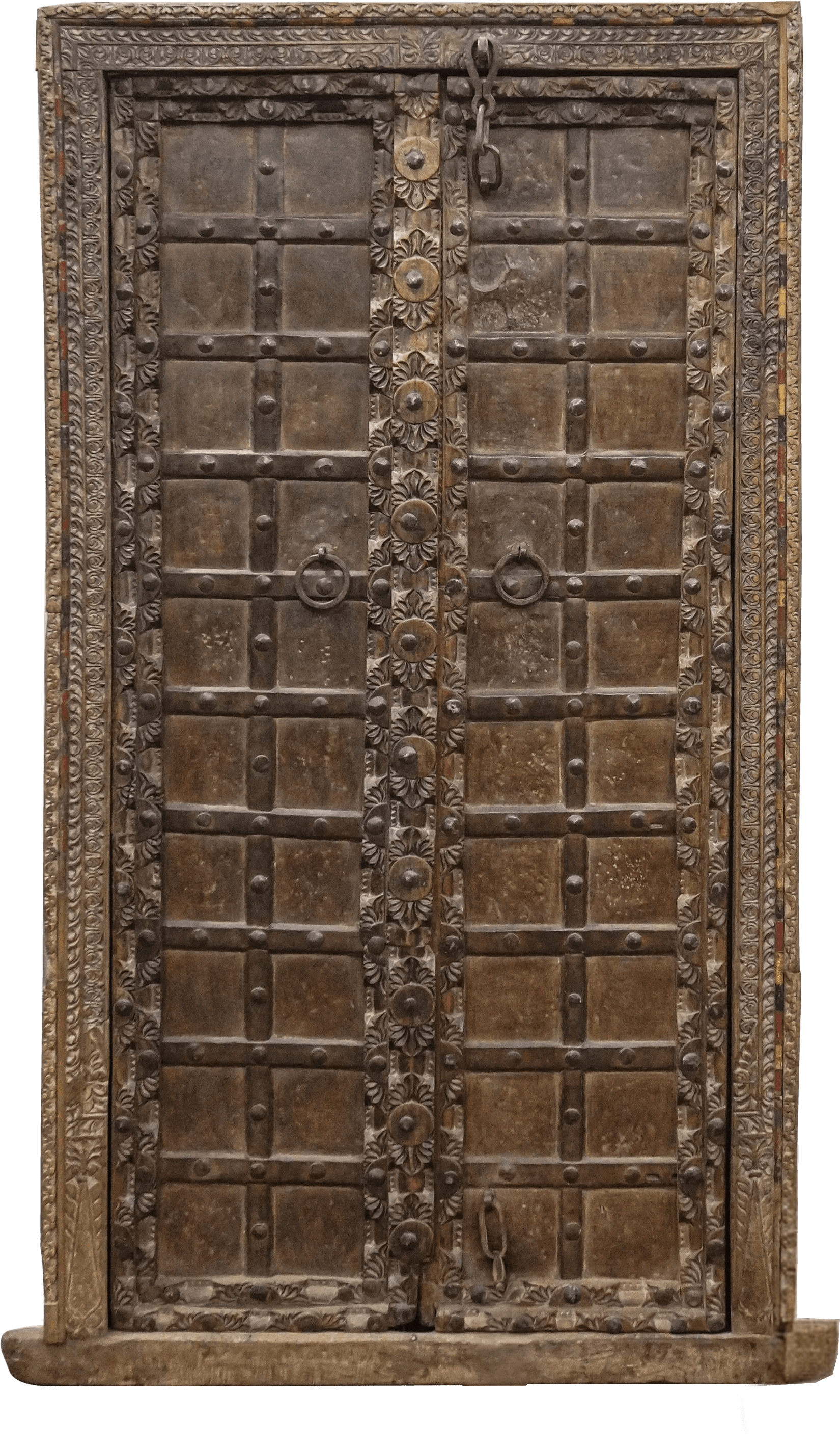 An antique, intricately carved wooden door.  The door is composed of two panels, each divided into a grid pattern by raised wooden beams.  Metal accents, including circular embellishments and metal hardware (hinges and possibly a lock mechanism), are visible. The frame of the door is also made of wood, with decorative carvings around the perimeter.  The wood appears dark brown or black with a worn appearance, suggesting age and use. A small wooden base or threshold is visible at the bottom. The overall style suggests a traditional, possibly Indian, design. — 3D model
