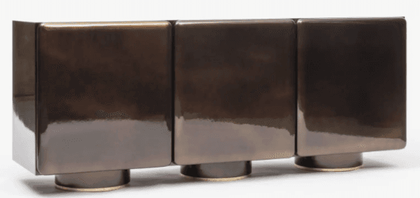 A credenza with a modern design, featuring three individual cubic sections, each with rounded edges. The unit is supported by short, cylindrical feet. The finish is highly reflective, giving the appearance of polished metal or lacquered wood. — 3D model