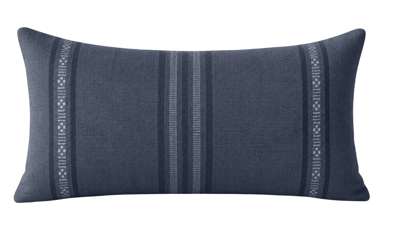 A rectangular lumbar pillow with a textured fabric surface. The pillow features a central pattern of vertical stripes in varying shades of blue and gray, flanked by decorative bands with a geometric woven design on either side. — 3D model