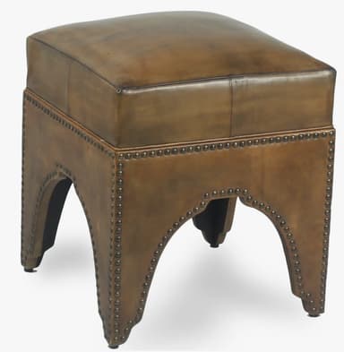 A square-shaped ottoman with a cushioned top, upholstered in what appears to be aged or distressed leather. The base is adorned with decorative brass or bronze nailhead trim. The sides of the base feature an arched cutout. — 3D model