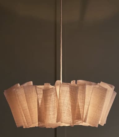 A sculptural pendant light featuring a pleated, light-colored, woven fabric shade suspended from the ceiling by a cord, emitting a warm, diffused light. — 3D model