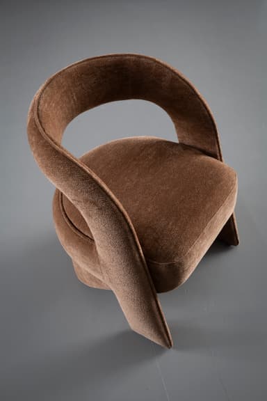 A contemporary sculptural accent chair fully upholstered in a textured medium brown fabric, featuring a continuous, curvilinear backrest and armrests that flow seamlessly into an integrated, upholstered cylindrical base. — 3D model
