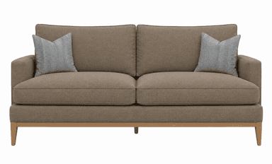 A contemporary two-seater sofa upholstered in a light brown, subtly textured fabric. It features a clean-lined silhouette with block arms and an exposed light wood frame base, including tapered legs. The sofa is furnished with two removable seat cushions and two back cushions, complemented by two light grey patterned throw pillows. — 3D model