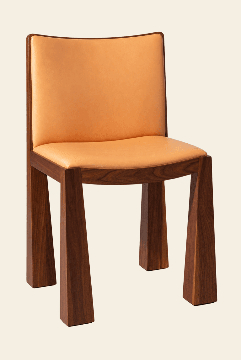 A modern armless chair featuring a sturdy dark wood frame and upholstered seat and back in light tan leather. The chair has thick, tapered legs with a block-like appearance, and a gently curved backrest. — 3D model
