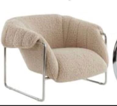 A contemporary lounge chair featuring a plush, light beige bouclé upholstery with channel tufting on the backrest, supported by a sleek tubular metal frame. — 3D model