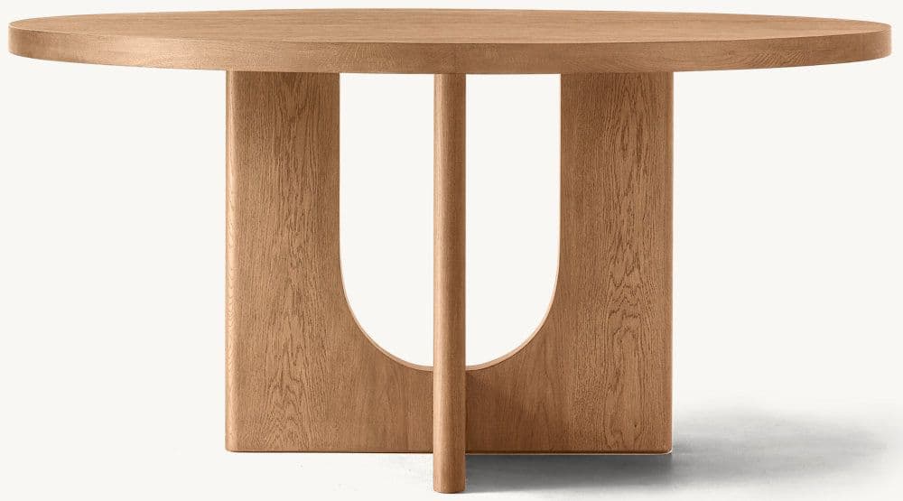 A round wooden table featuring a distinctive sculptural pedestal base. The tabletop is thick and has a smooth, natural wood finish. The base consists of two substantial U-shaped wooden supports, oriented perpendicularly to each other, with a central cylindrical rod connecting them from the floor to the underside of the tabletop. The wood displays a prominent grain, suggesting a solid hardwood construction. — 3D model