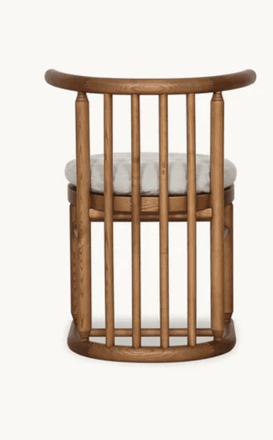 A robust wooden armchair featuring a distinctive tub or barrel back design composed of multiple vertical spindles. It has a curved top rail that forms both the backrest and armrests, supported by turned posts. The chair includes a circular, light-colored upholstered cushion for the seat, complementing the medium-toned natural wood frame. The base mirrors the spindle design, offering a sturdy and cohesive aesthetic. — 3D model