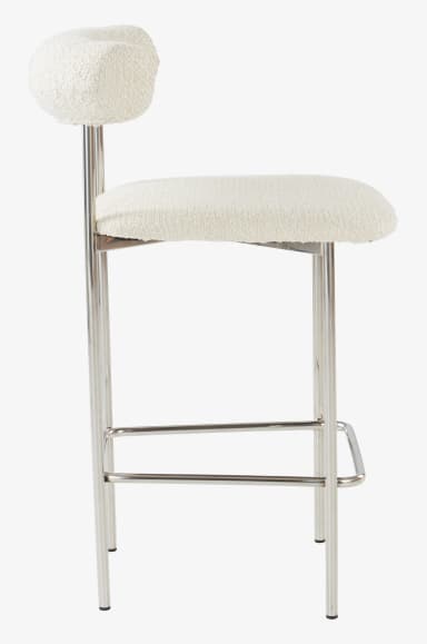 A bar stool with a curved backrest and a padded seat. The frame and legs are constructed from polished metal tubing, featuring a horizontal footrest connecting the front and back legs. The upholstery appears to be a textured, boucle-like fabric in a light cream or off-white color. — 3D model