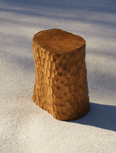 A compact, solid wood side table featuring a distinctive hand-carved, textured surface on its cylindrical body and a smooth, flat top, revealing the natural wood grain. The carving gives it an organic, chiseled appearance. — 3D model