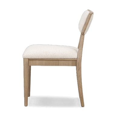 A dining chair with a wooden frame and upholstered seat and backrest. The seat and backrest are covered in a textured, light-colored fabric. The wooden frame has a light, natural finish and features a fluted design along the apron below the seat. The backrest is rectangular with gently rounded corners and is supported by two curved wooden uprights. — 3D model