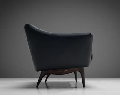 A three-seater sofa with a curved backrest and armrests, upholstered in dark leather. The seat is composed of three distinct cushions. The sofa is supported by four tapered wooden legs. — 3D model